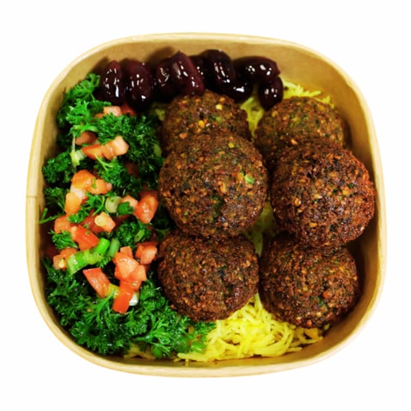 Falafel bowl with yellow rice, fresh parsley salad, and dark sauce in a cardboard container.